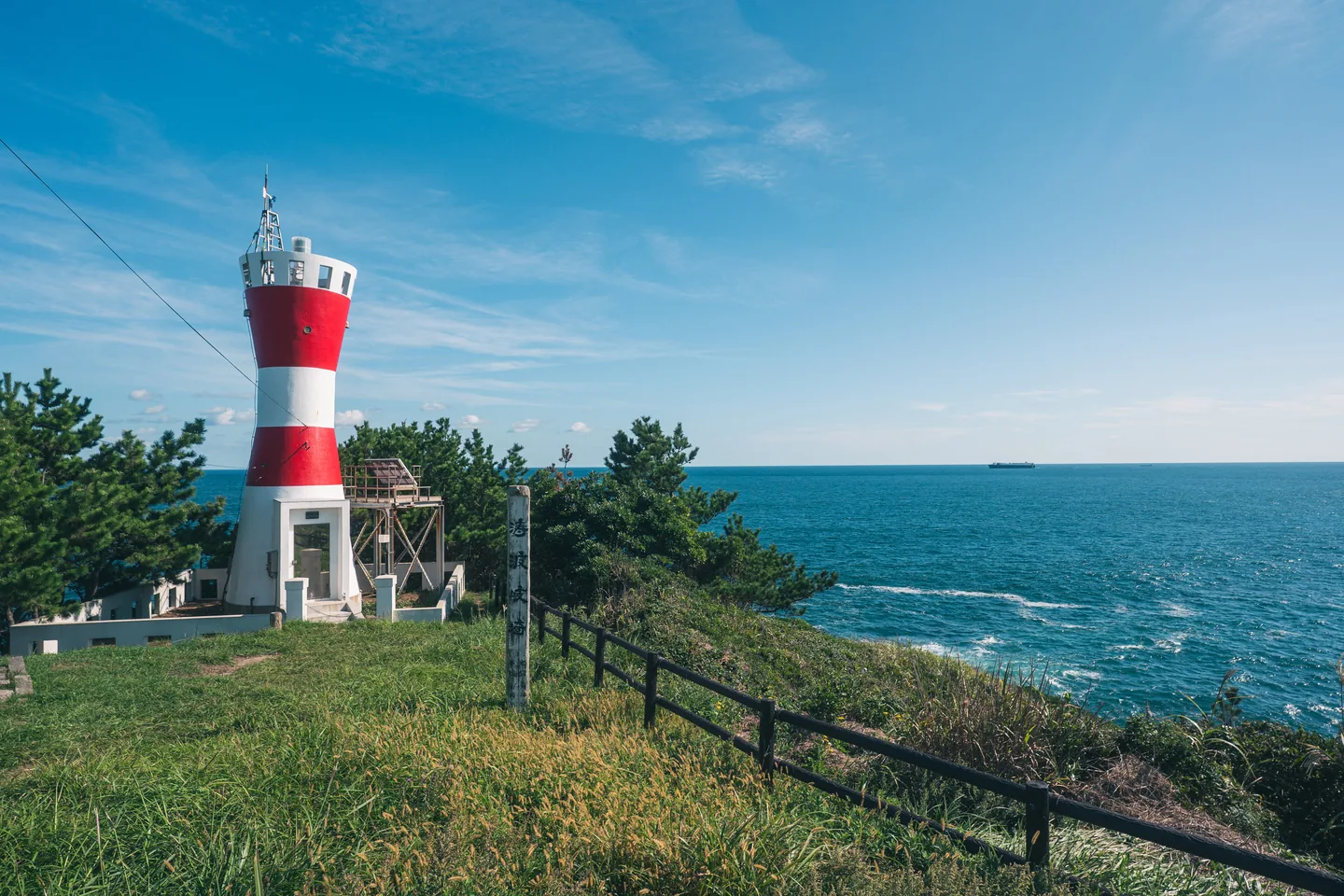 海を背景に立つ赤白の灯台